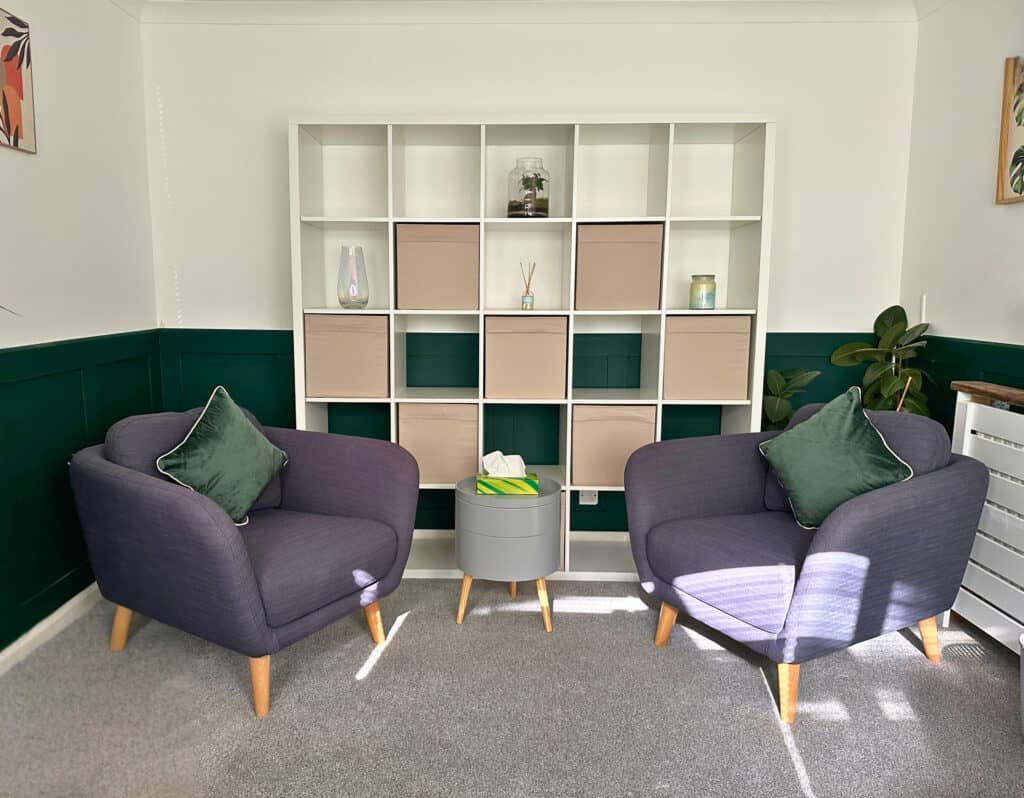 A calm, ADHD‑friendly counselling room in Plymouth with two comfortable chairs, soft lighting and gentle green accents, designed to support adults who experience overwhelm, sensory sensitivity and executive function challenges.